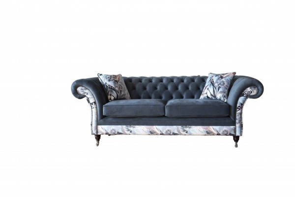 Ein auffälliges Dreisitzer-Sofa im Chesterfield-Design mit zarter grauer Blumendekoration
